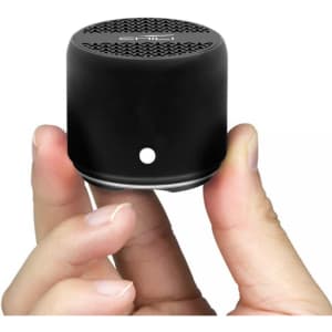 A compact black Bluetooth speaker held in a hand, featuring a textured top and a minimal design.