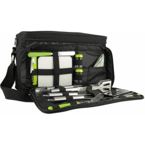 A black picnic bag with green accents, containing utensils, a cutting board, drink bottles, and a napkin.