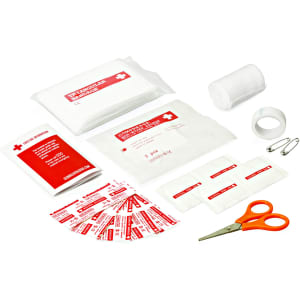 A first aid kit featuring various bandages, gauze, scissors, safety pins, and adhesive tape, in a red and white design.