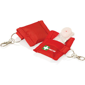 A red keyring pouch containing a CPR mask, featuring a first aid logo and a clip for attachment.