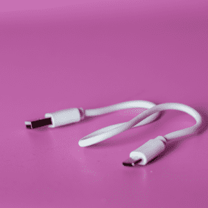 A white USB charging cable on a pink background, featuring standard and USB-C connectors.