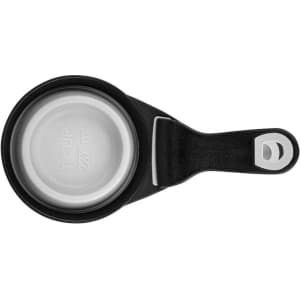 A collapsible silicone pet food scoop in black, featuring a metallic measuring cup and a handle with a loop for easy storage.