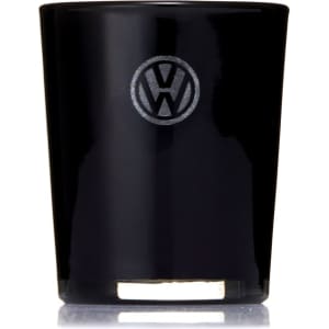 A black glass candle with a circular logo on the front, featuring a metallic base.