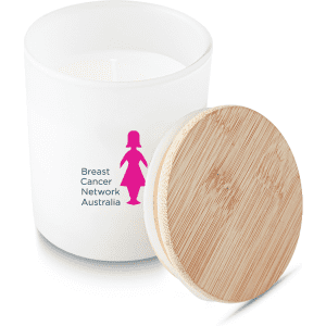 A medium white candle with a bamboo lid, featuring a logo on the front in pink.