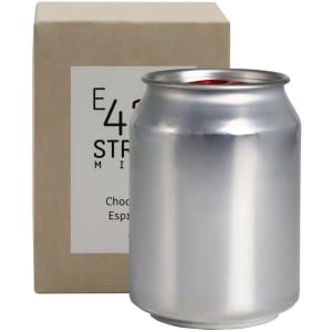 A silver can candle next to a light brown box. The candle has a minimalist design and is labelled as "Choc Espresso".
