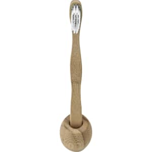 A bamboo toothbrush with a natural wood finish and white bristles, placed in an upright holder.