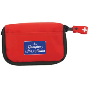 A red first aid travel kit with a zippered closure, featuring a logo on the front.