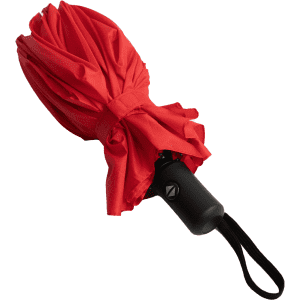 A red umbrella with a black handle, featuring a logo on the handle, secured with a strap.