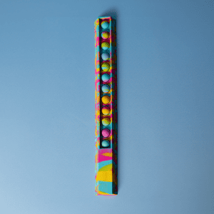 A colourful 30cm popper ruler with a vibrant design and multiple popping buttons along its length, featuring a logo.