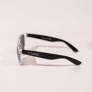Transparent framed sunglasses with black arms, featuring a logo on the side.