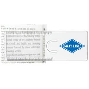 A clear magnifying ruler with a logo, placed over text in a book, featuring a built-in handle.