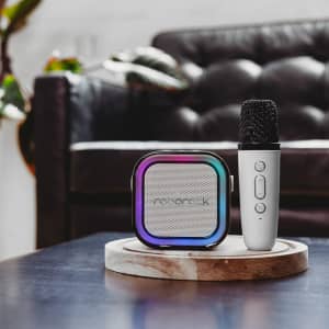 A portable karaoke machine in black and silver with a multi-coloured speaker design, accompanied by a silver microphone.