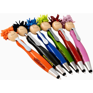 A set of six colourful Mop Head Pens with Stylus, featuring playful character toppers, displayed on a desk.