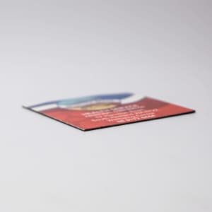 A 50mm x 50mm fridge magnet with a colourful design and a logo on it, featuring a flat edge.