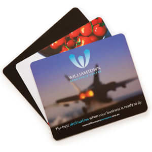 A set of three mouse mats featuring vibrant images, including a blurred aircraft and tomatoes, with a logo on one.