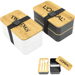 A two-layer lunch box set featuring a white and a black container with bamboo lids and a strap, includes utensils.