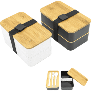 Two-layer lunch box in white and black with a bamboo lid and a black strap; includes utensils inside the black section.
