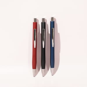 Three ballpoint pens in red, black, and blue, featuring sleek designs and silver clips, displayed against a light background.