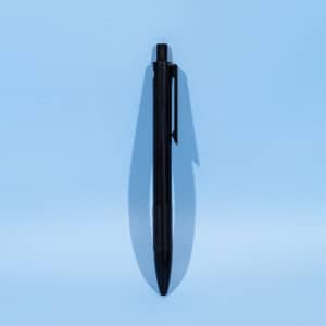 A black eco plastic ball pen lies flat against a light blue background. It features a clip and a rounded tip.