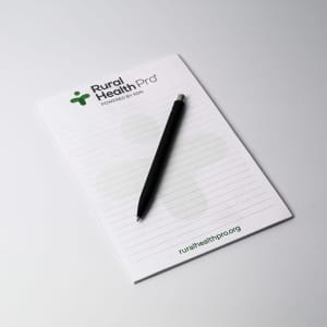A5 notepad with 25 leaves, featuring a white background and a black pen, includes a logo at the top.