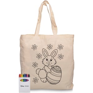 A cream calico tote bag with a bunny design and a set of colourful crayons beside it. Features a brand logo.