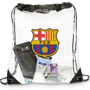 A clear drawstring bag featuring a logo, with a phone, sunscreen, and personal items inside. The bag has black straps.