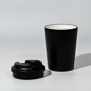 A black travel cup with a removable lid, featuring a sleek design and a contrasting inner colour.