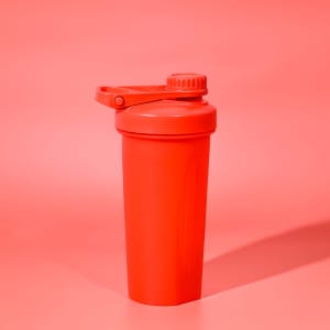 A drink bottle in vibrant red, featuring a screw-on lid and a flip-top cap, with a logo.