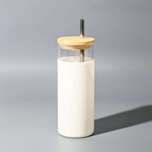 A drink bottle featuring a clear container with a white exterior and a wooden lid, complete with a metal straw.