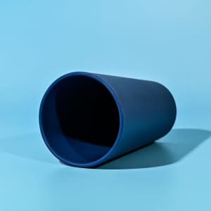 A drink bottle in a deep blue colour, featuring a simple design and a branding logo.