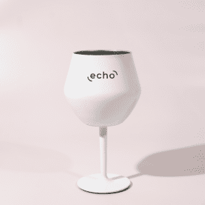 A white Shiraz detachable wine glass with a black interior and a stand, featuring a logo.