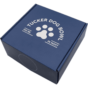A navy blue box containing the Tucker Dog Bowl, featuring a paw print design and branding on the lid.