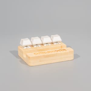 A bamboo stand holder featuring four white key-shaped stress relievers, with a logo on the base.