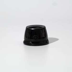 A black speaker with a rounded design, featuring a smooth surface and a small branding element at the front.