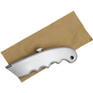 A silver cutter with a textured handle resting on a piece of brown paper. The item has a brand logo.