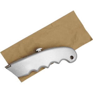 A silver cutter with a textured grip positioned on brown packaging paper, featuring a logo.