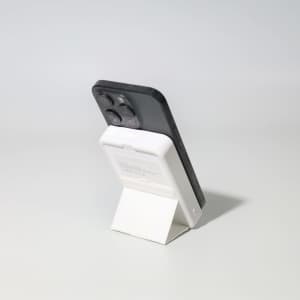 A black and white Turbo 5000mAh wireless charging power bank set on a stand, showcasing its sleek design.