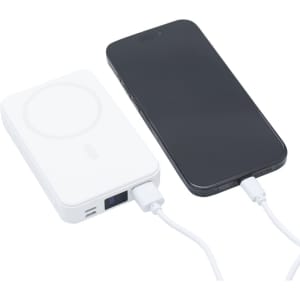 A white 5000mAh wireless charging power bank next to a smartphone, both connected with a charging cable.