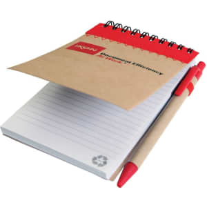 A recycled jotter pad with a brown cover, spiral binding, and a red accent, accompanied by a red pen.