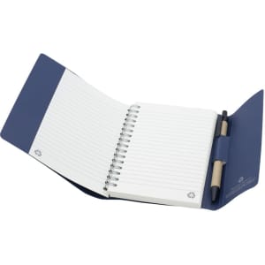 A small tuck journal book in navy blue with spiral binding and blank lined pages, featuring a holder for a pen.