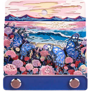 A 3D paper-cut sculpture notepad featuring colourful butterflies and flowers, with a hanging loop and a blue base.