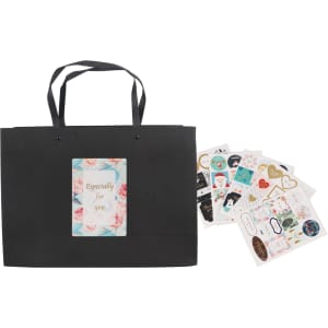 A black large crosswise paper bag with knitted handles, accompanied by various decorative stickers.