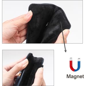 A black putter cover being held, featuring a soft textured surface and a magnetic closure.