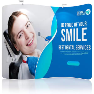 A blue and white S-shaped tension fabric display wall featuring a smiling woman receiving dental care and a logo.