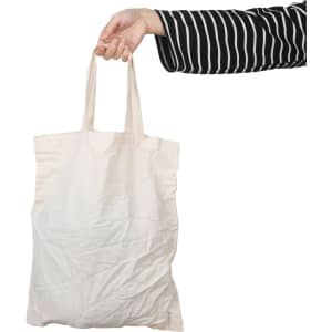 A short handle calico bag in natural beige held by a hand, featuring a plain design and a logo.
