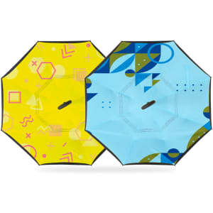 A reversible folding umbrella featuring a bright yellow side with geometric patterns and a blue side with abstract designs.