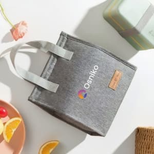 A grey minimalist lunch bag with a logo, featuring sturdy handles and a simple design.
