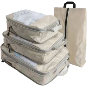 A set of four beige travel packing cubes with mesh tops and a matching carrying bag.
