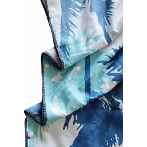 A hooded change towel in shades of blue and white with a palm leaf design, featuring a branded logo.