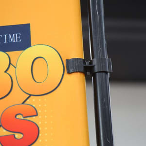 A side panel of a table top banner features vibrant yellow and orange colours, secured to a black support.